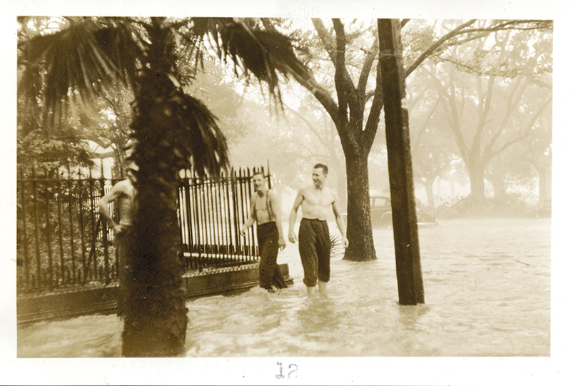 Two men wade at the corner of Meeting and South Battery, and cars are flooded at the end of King Street and South Battery.  Photograph courtesy of The Charleston Museum