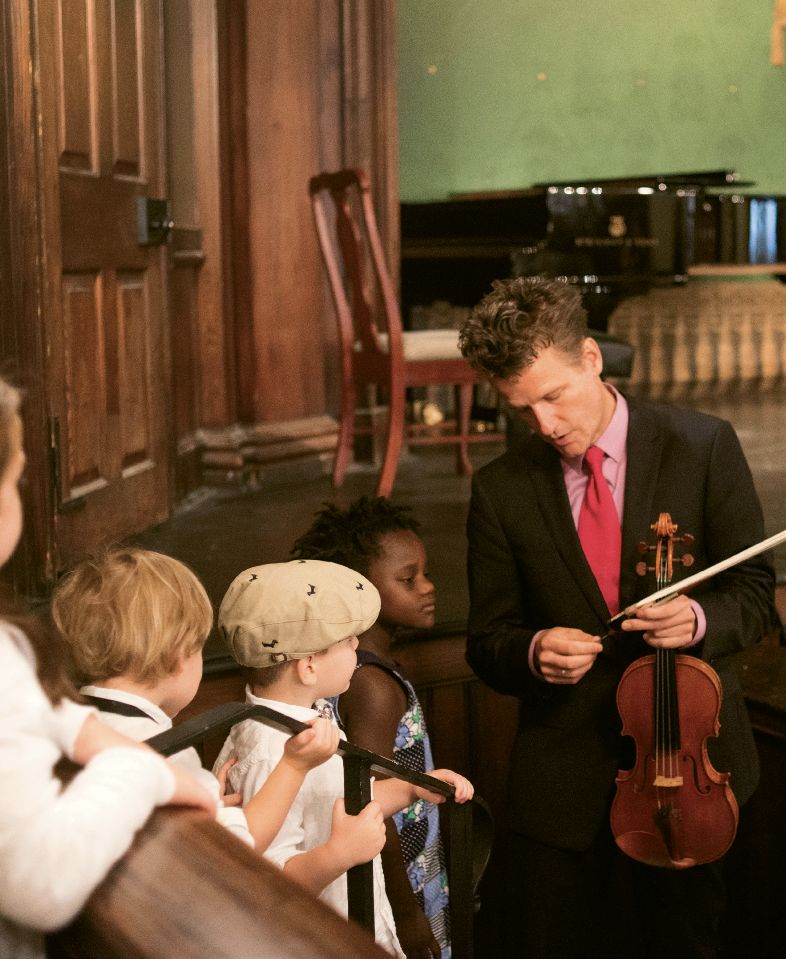 Child’s Play: Every festival season, Nuttall spends about six hours with local kids for outreach programs. Here, some children get a close look at Nuttall’s violin and bow after a special concert for individuals with autism and their families.