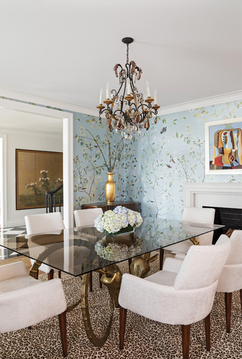 Pattern Play: A Stark leopard-print carpet ties this room of contrasts together. Calming floral wallpaper is countered by the bold bronze ibex-head table bases, and two vintage Anne Hauck cabinets with bronze inlay add weight to the room.