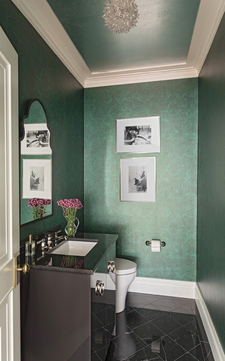 GREEN With Envy: This striking “Agate” mica-coated paper by Aux Abris has an luminescent quality that lights up the small, first-floor powder room. A black marble floor and vanity are complemented by black-and-white photography, letting the walls take center stage.