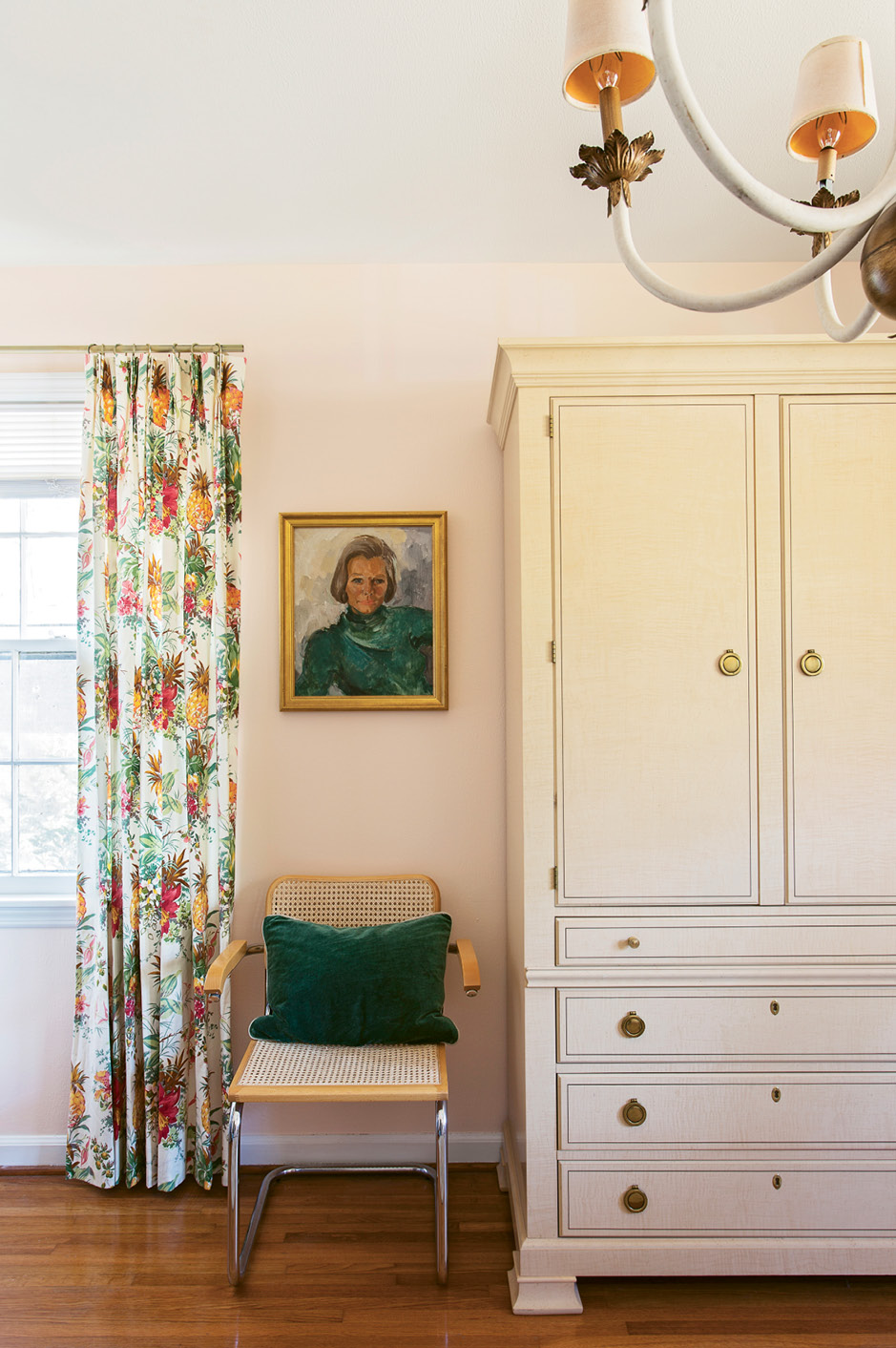 VINTAGE VIBE: In Tinkler’s home office, an antique Drexel armoire provides a handsome home for paperwork. Caned chairs, botanical textiles, and an antique portrait in a gilt frame lend a laid-back glamour to the work space.