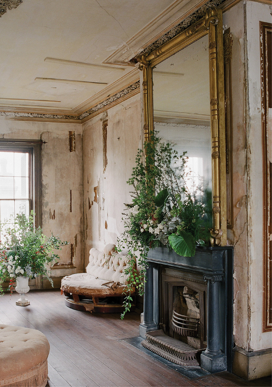 In the Aiken-Rhett’s second-floor drawing room, a mantel bursts with Japanese maple, trailing ivy, spray roses, dusty miller, nandina, elephant ears, and more.