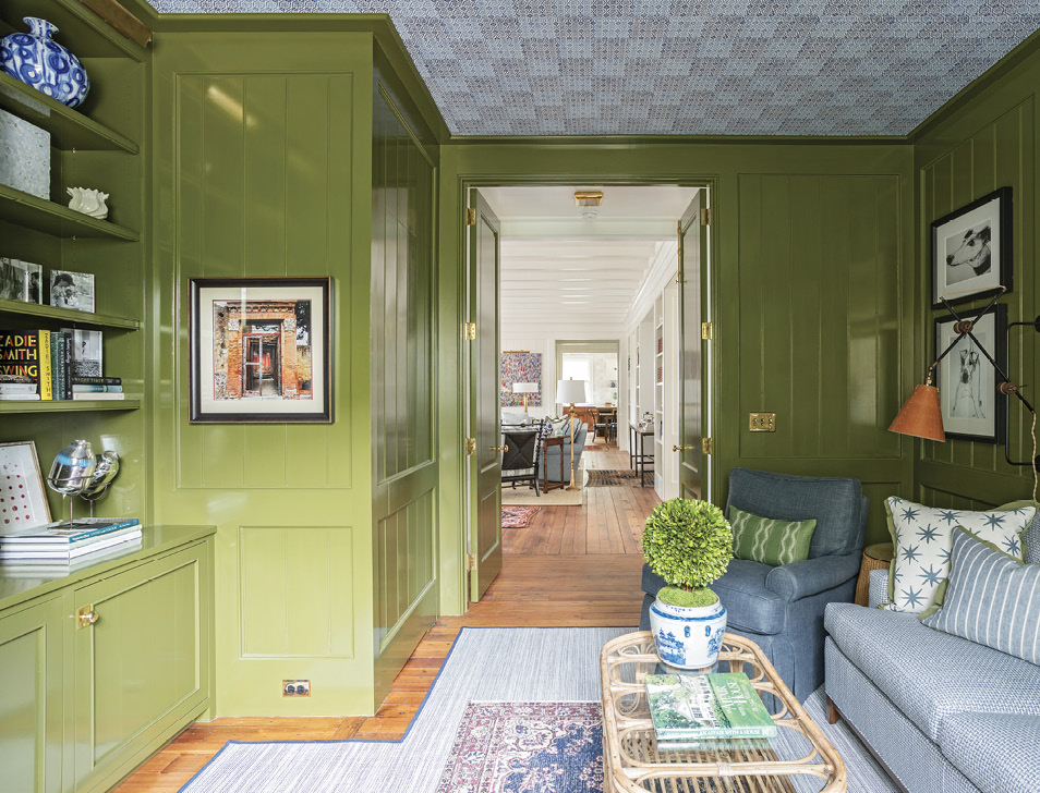 Lacquered in Farrow &amp; Ball’s bold green “Bancha,” the adjoining media room is a cozy place to watch a movie or curl up with a good book. Peter Fasano wallpaper on the ceiling gives the feel of mosaic tile.