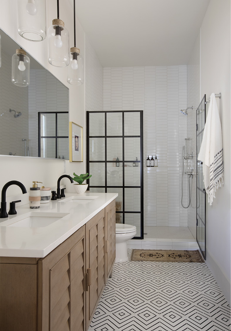 GRAPHIC DETAIL: Geometric Riad floor tiles pick up on splashes of black in the paned shower door and Delta Trinsic fixtures in this streamlined master bath