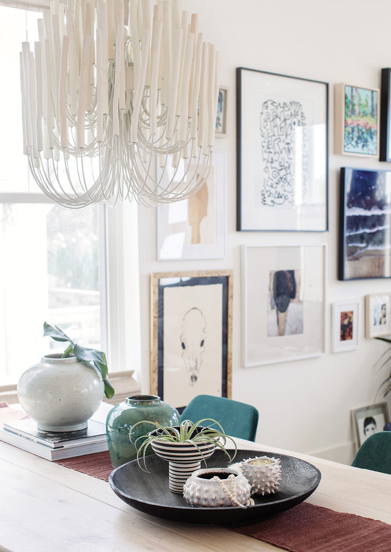 SUBTLY DRAMATIC: A whitewashed wood chandelier from Arteriors hangs over the dining table helping delineate the dining area from the living room.