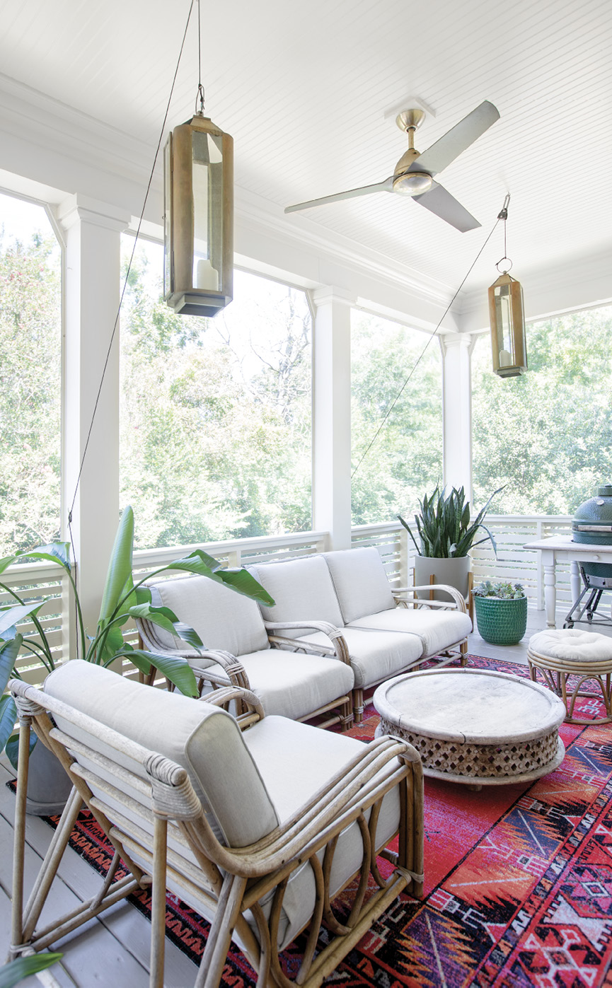 Chill &amp; Grill: Newly screened-in, the back porch off the main living area offers more space for cooking and entertaining. Erin had the vintage rattan seating recovered by Aiden Fabrics, and Spence created a pulley system for the lanterns.