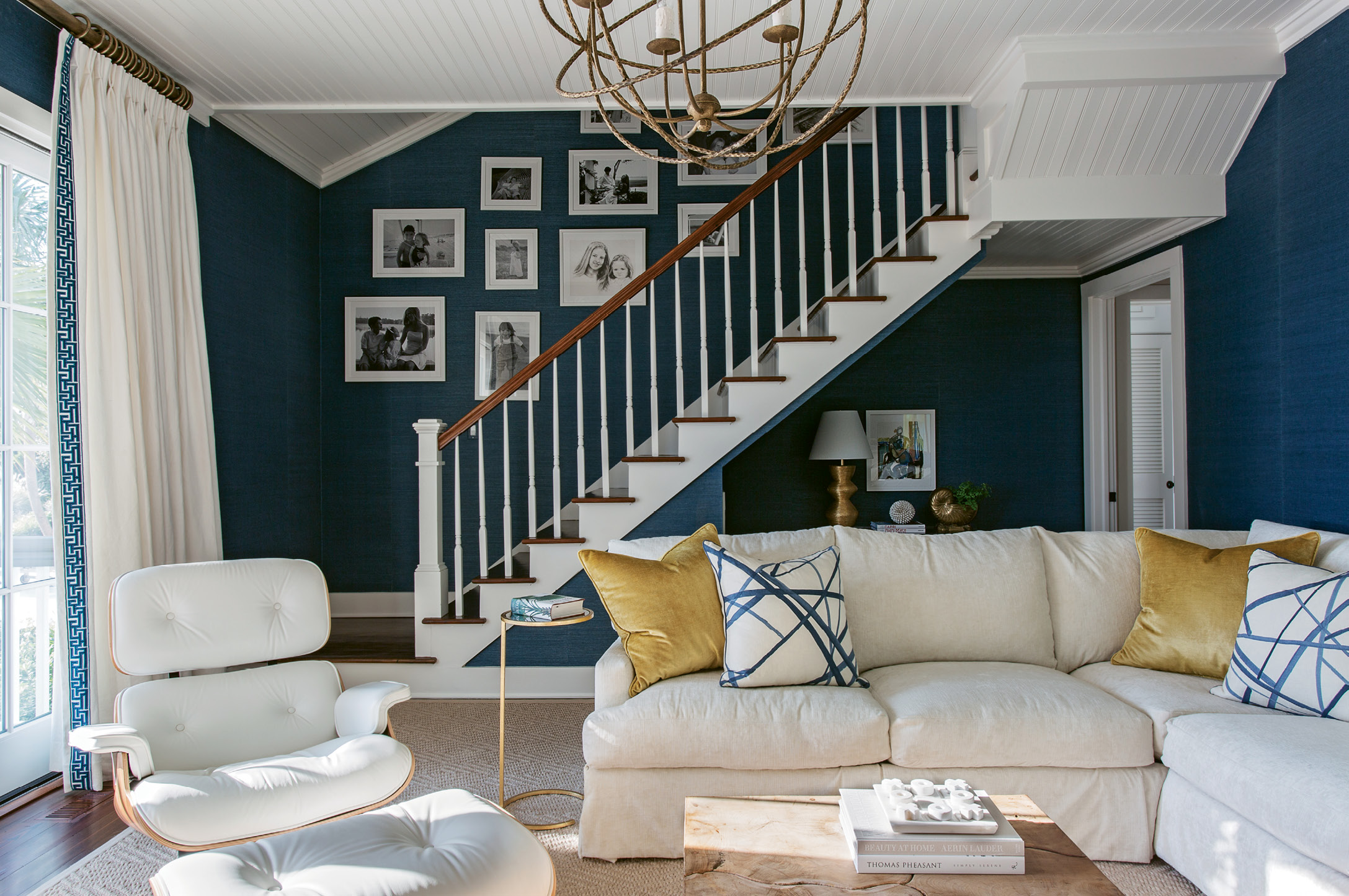 BLUE ZONE: In the den, the Kings opted for grass-cloth wallpaper by Phillip Jeffries in a navy in keeping with the coastal color palette. “It reminds me of the Mediterranean,” says Tara.