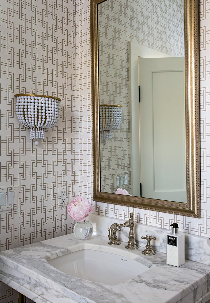 Elebash dressed up the powder room with geometric wallpaper from Romo and a beaded sconce from Circa Lighting.