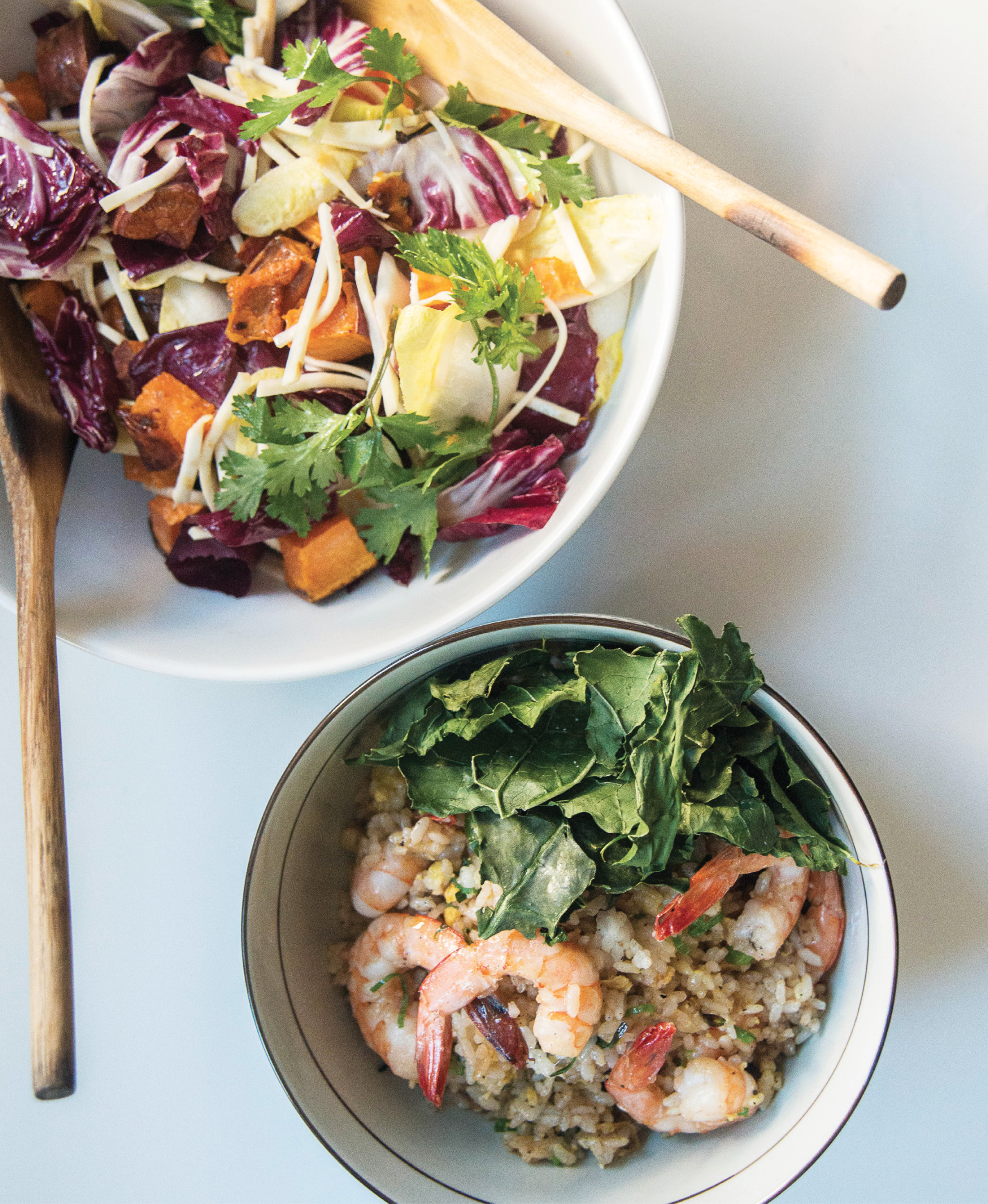 Bowls of the celery root and sweet potato salad and shrimp fried rice; Walker and Li top the rice with crispy baked kale, a healthier alternative to deep- fried garnishes.
