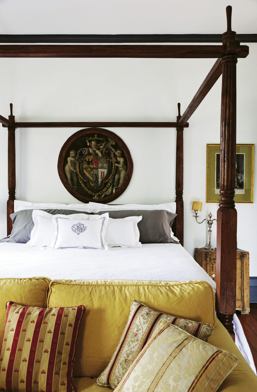 An Indonesian four-poster bed and the della Porta family crest on canvas in the master bedroom
