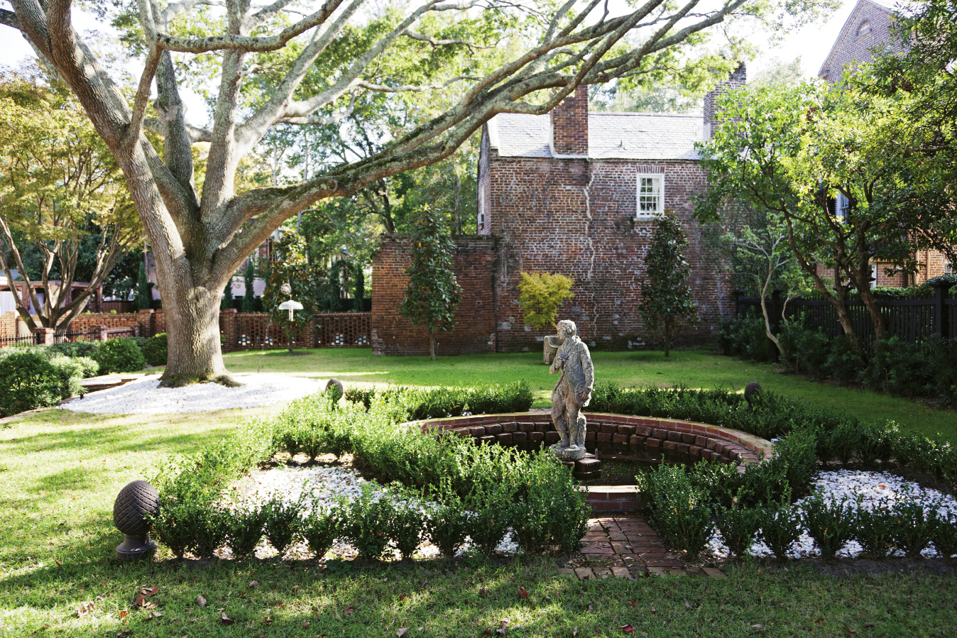 The original owner also purchased the  adjacent lot to house a garden; the courtyard, punctuated by a stately live oak and a French statue, is protected by a conservation easement.