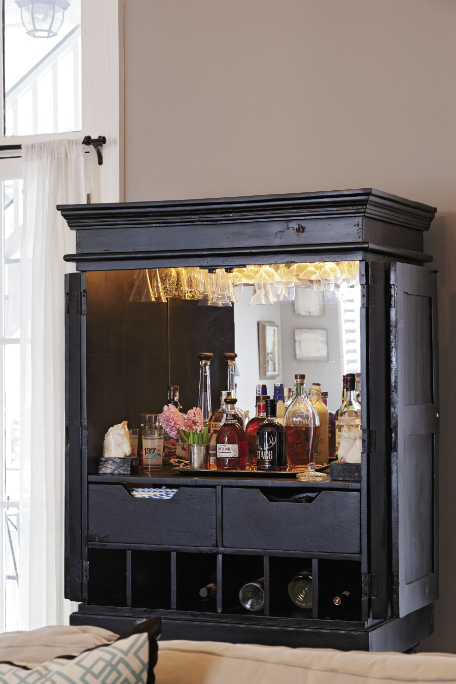 HIGH PROOF A repurposed highboy with mirrored back is well-stocked with all-things Kentucky, i.e. bourbon.