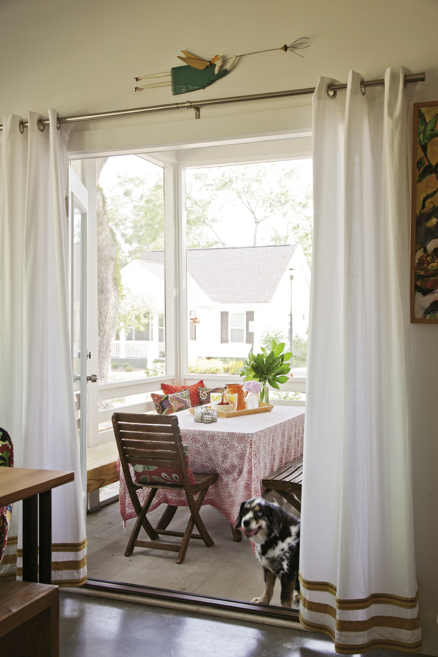 Textiles—some new, others collected over time—brighten the screened-in porch.