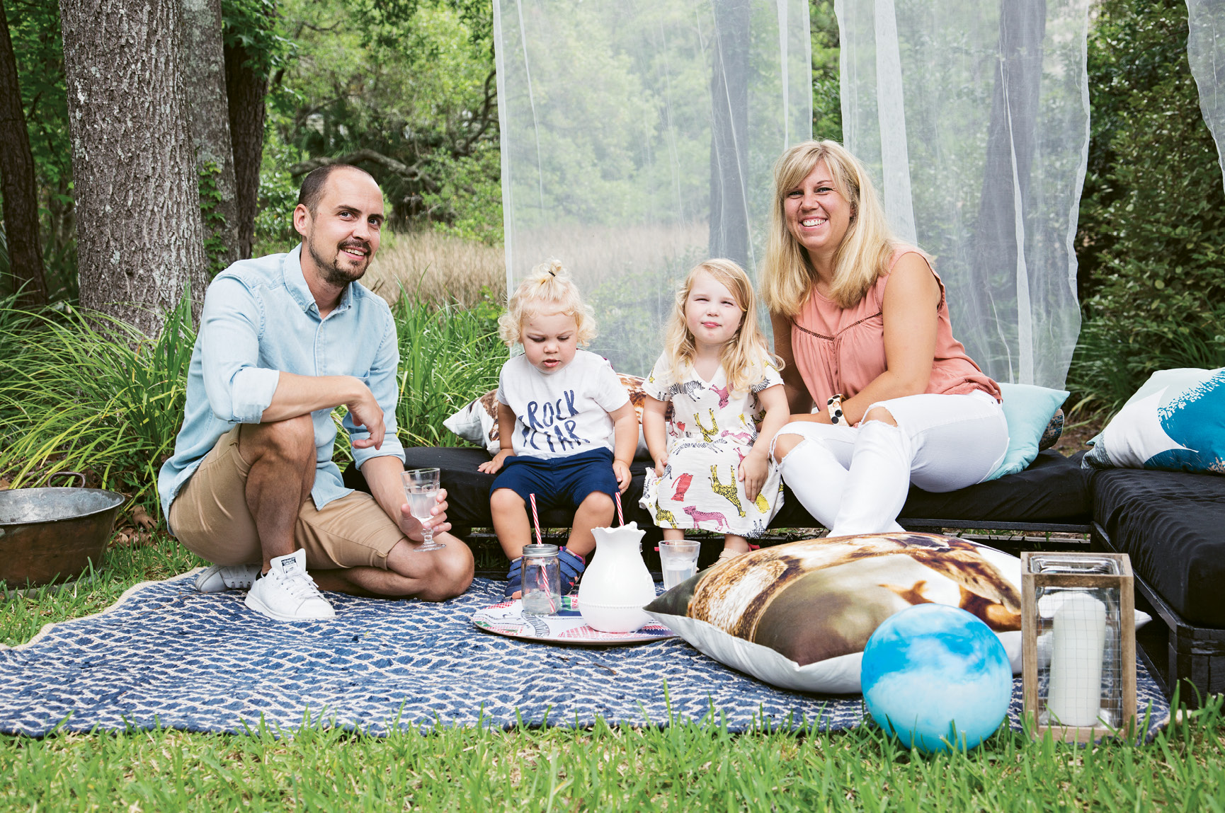 FAMILY TIME: Jacob and Therese Lenberg picnic with their children in their Hobcaw Creek backyard. The Swedish couple’s abode is chock-full of Scandinavian style, beginning with the entryway (left), where one clock is set to local time and another displays the hour in their hometown of Gothenburg.
