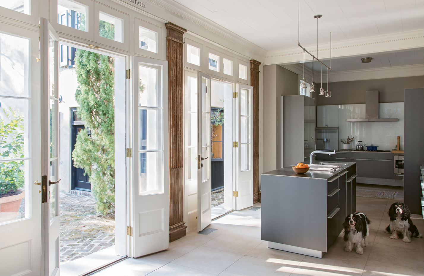 Sleek cabinetry by Bulthaup commingles with antiqued pilasters in the kitchen, located within what was once the rear porch.