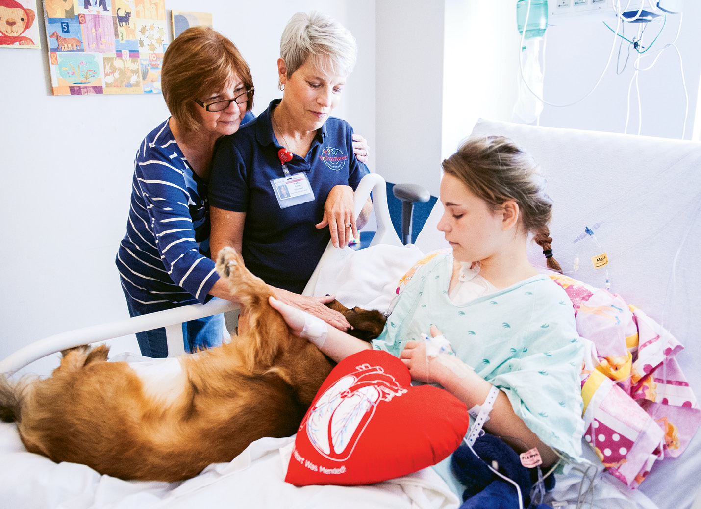 Kathy Sykes (standing at right) brings pooches Bristol—shown with young Sydney and a family member—and Maddie to MUSC twice a week.