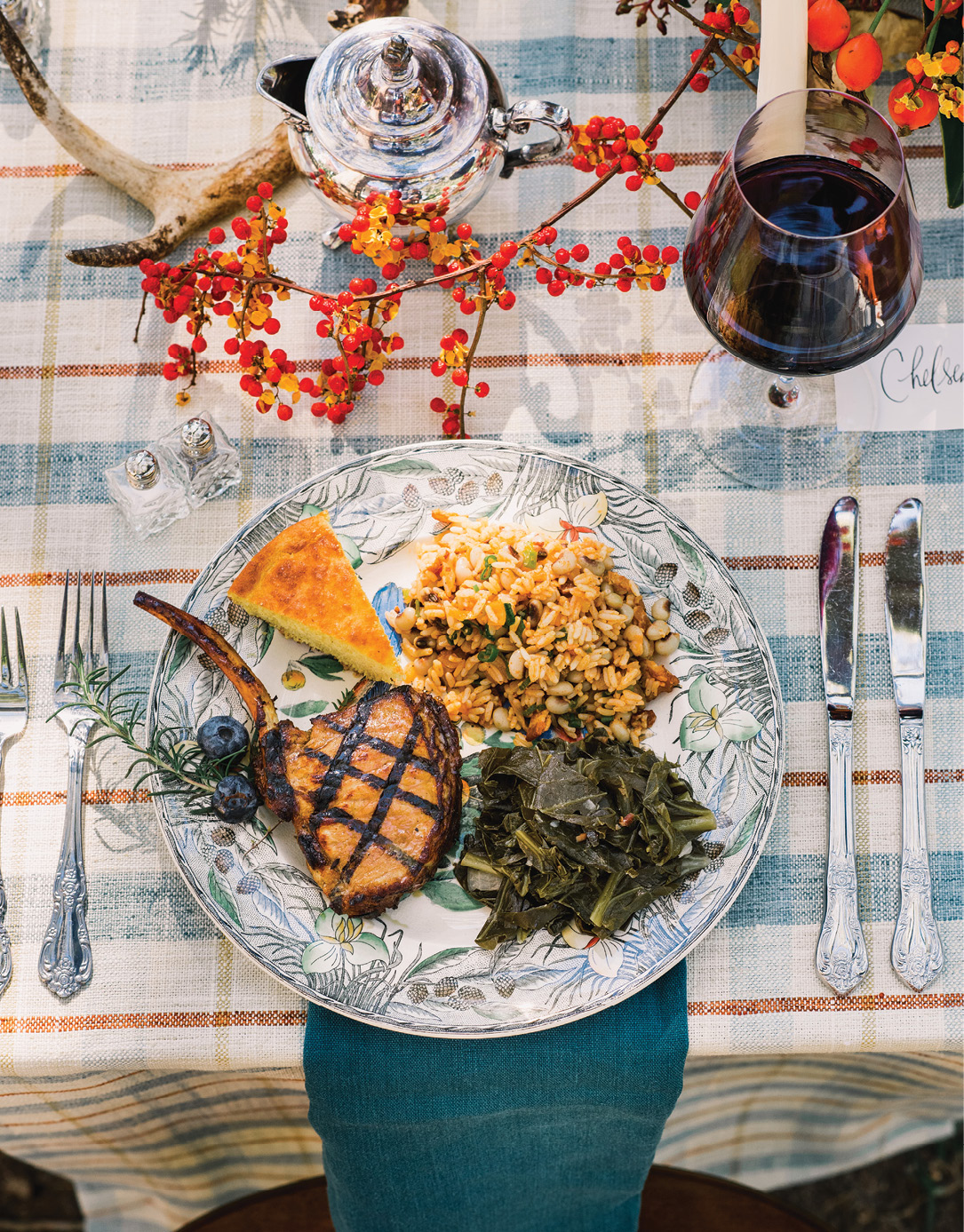 Each household sits at their own table with the sides they made served family-style. The host wore a mask and gloves to grill pork chops for all.