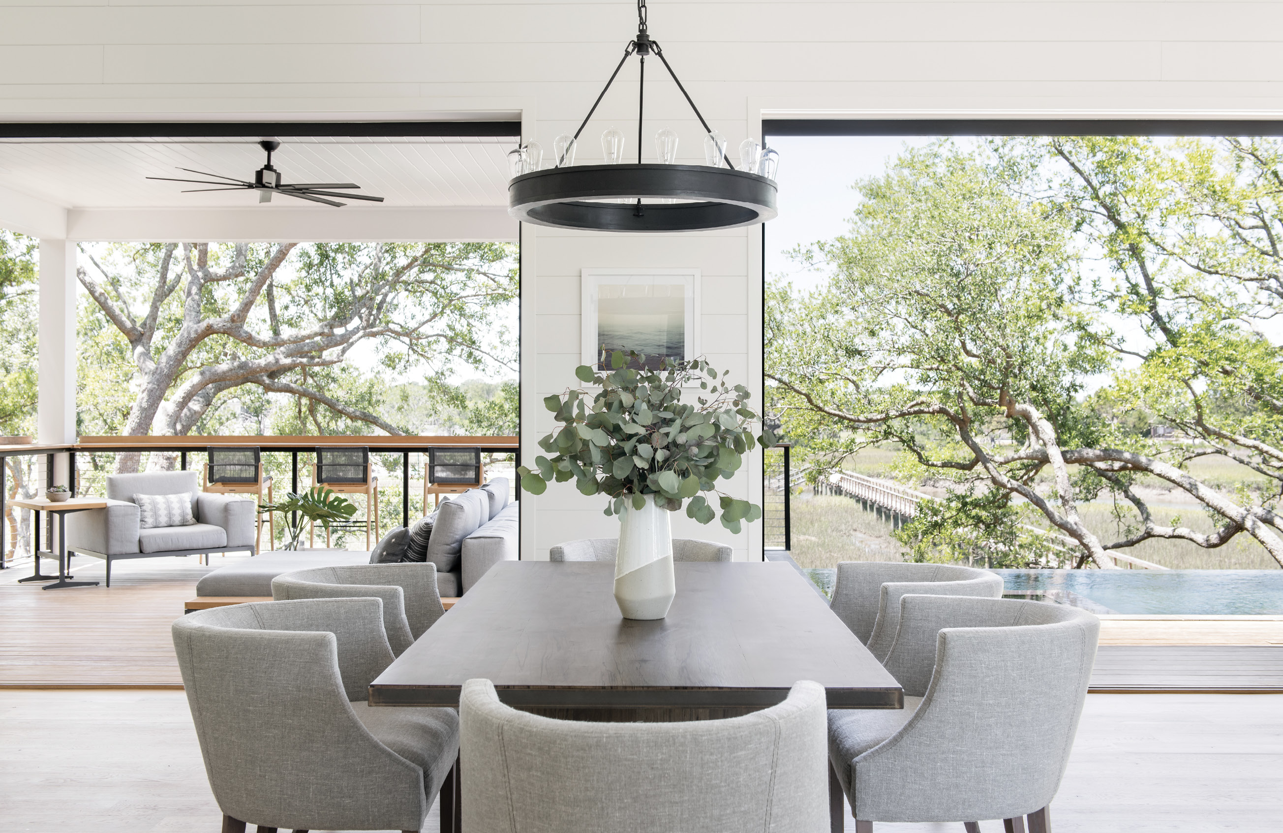On A Limb: “From the start, my clear goal was to bring the outdoors in for an open-living, tree-house concept,” explains Melissa Lenox, who designed the interiors of the home. “All main living spaces and the master were intended to bring the unique and beautiful Lowcountry nature indoors.” She chose neutral colors for the furniture, such as the HomeNature sectional and Verellen dining chairs, and incorporated soft marsh hues in accent pieces like paintings, rugs, and pillows.
