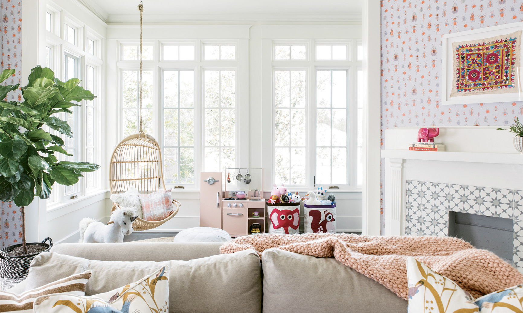 In the vibrant playroom, comfy, kid-friendly furniture—like the Serena &amp; Lily hanging chair and Lee Industries pullout sofa outfitted in performance fabric—mix with playful décor, including a vintage textile interior designer Melissa Lenox found in Jodhpur, India, and Lulie Wallace’s “Meyers” wallpaper.
