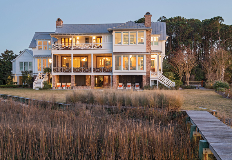 MARSHFRONT MAGIC: A curved lot with expansive views on three sides, taking in the Intracoastal Waterway, the Ben Sawyer Bridge, and Charleston in the distance, was the inspiration for this classic Lowcountry beach house designed by Beau Clowney and built by Structures.