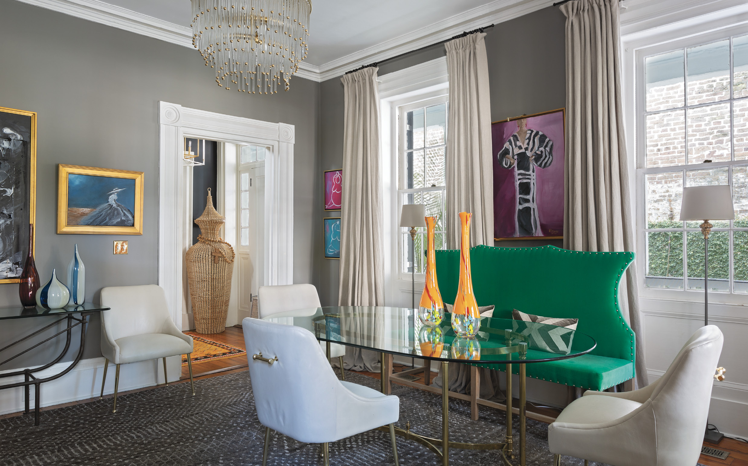 Something Old, Something New: Bold colors, eclectic art, contrasting fabrics, and a smattering of antiques turn a formal sitting room into a dynamic space. The glass dining table from Patricia Allen Antiques at Fritz Porter dispenses with formality, thanks to white leather chairs from Anthropologie and a green velvet settee from South of Market downtown.