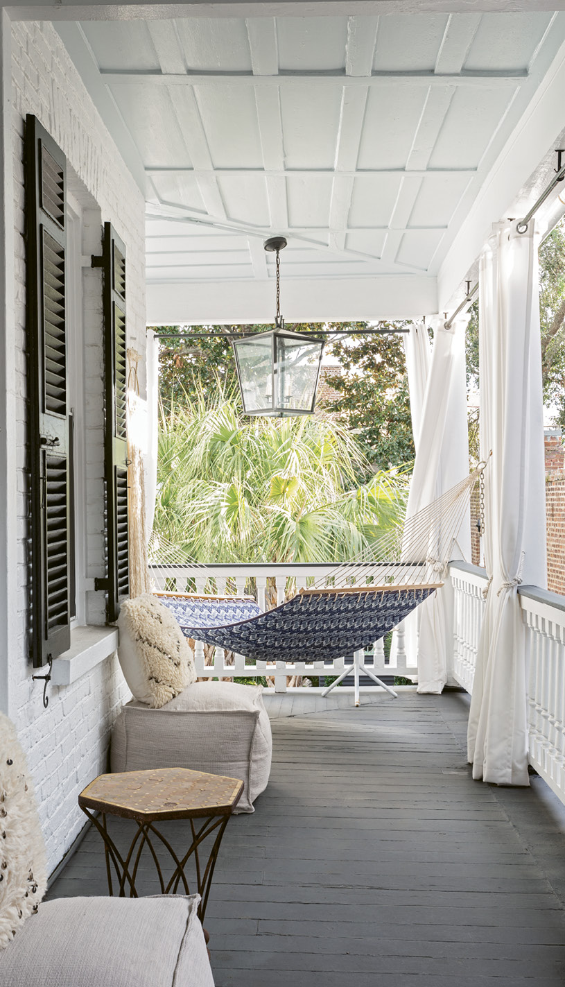 A Relaxing Perch: The upstairs porch provides a pleasant respite from everyday cares, with a hammock and Restoration Hardware Moroccan wedding pillows precisely positioned to take in the treetop views.
