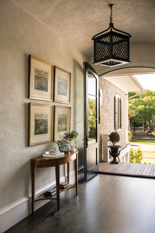 Arched mahogany doors lead into a barrel ceiling with plaster walls, adding sophistication to the entryway.