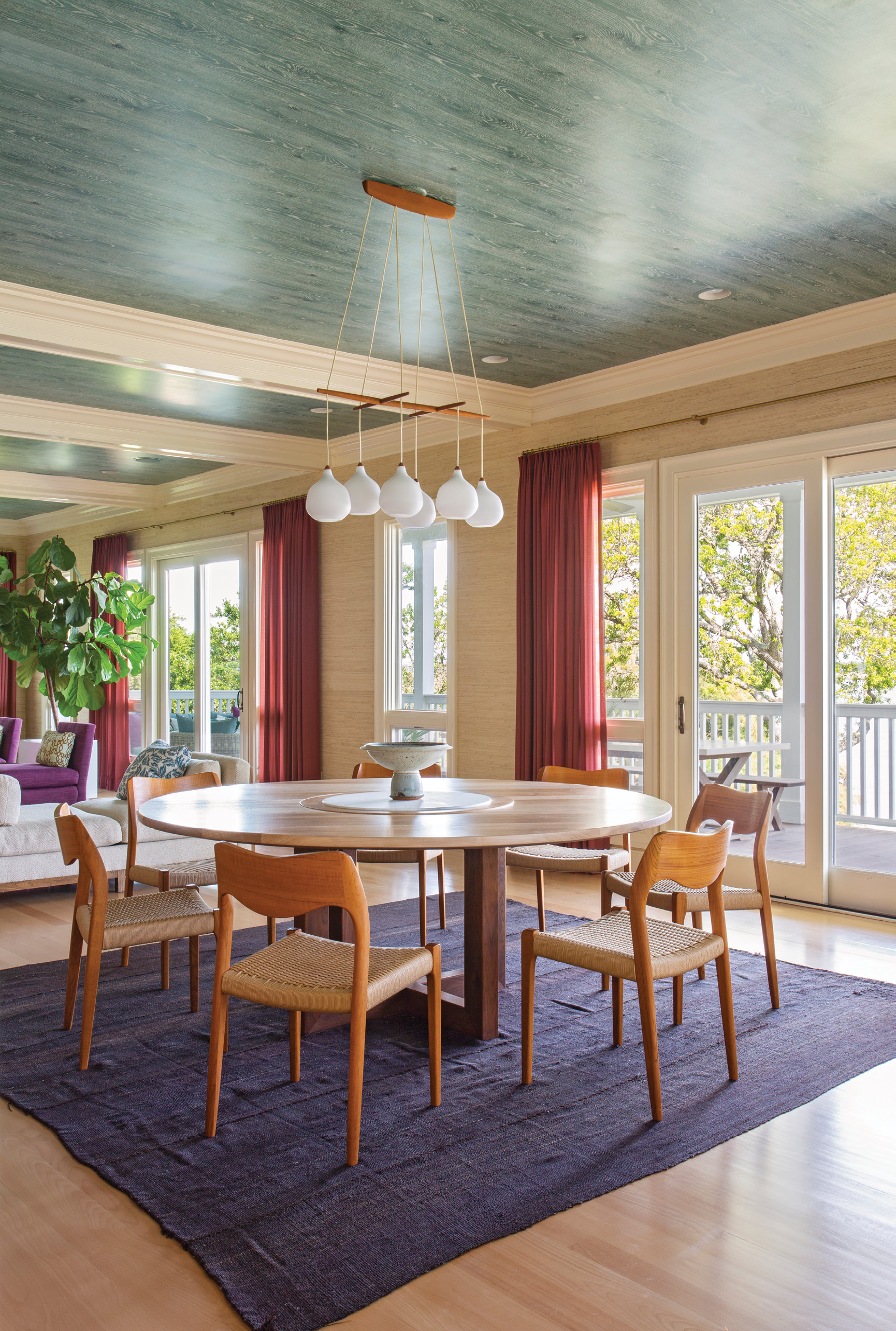 “A round table was definitely called for here,” says Hranowsky, who was seeking to balance the kitchen’s linear shapes. Her carpenter custom created the walnut dining table, outfitted with a marble lazy Susan that was Phil’s engineering. A vintage Danish teak and white glass chandelier from 1stDibs adds casual spunk to the dining room without obstructing views into the kitchen or out to the waterway.