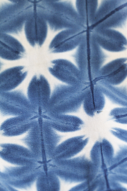 A cloth dyed in the Japanese shibori method, a technique of binding and dyeing fabric to achieve a pattern, in this case “snowflake;”