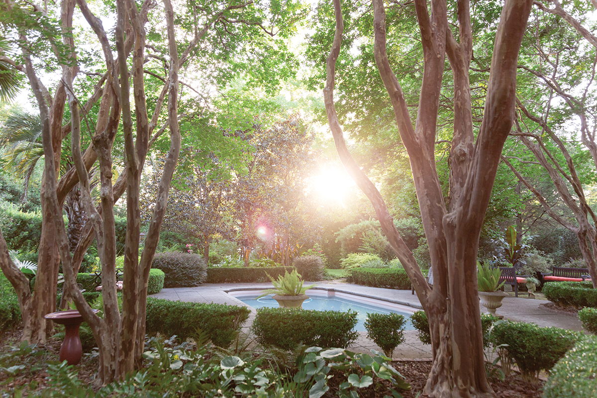 Room to Relax: Today, the pool area feels like a secluded retreat. Hedges provide crisp outlines to less-formal plantings, such as the tractor-seat plants and ferns in the butterfly-shaped parterres linking this scenic play space to the house.