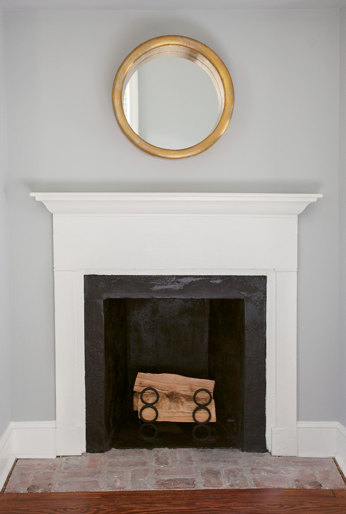 A perfectly simple gilded mirror from Antiques of South Windermere hangs above the fireplace mantel in the guest room.