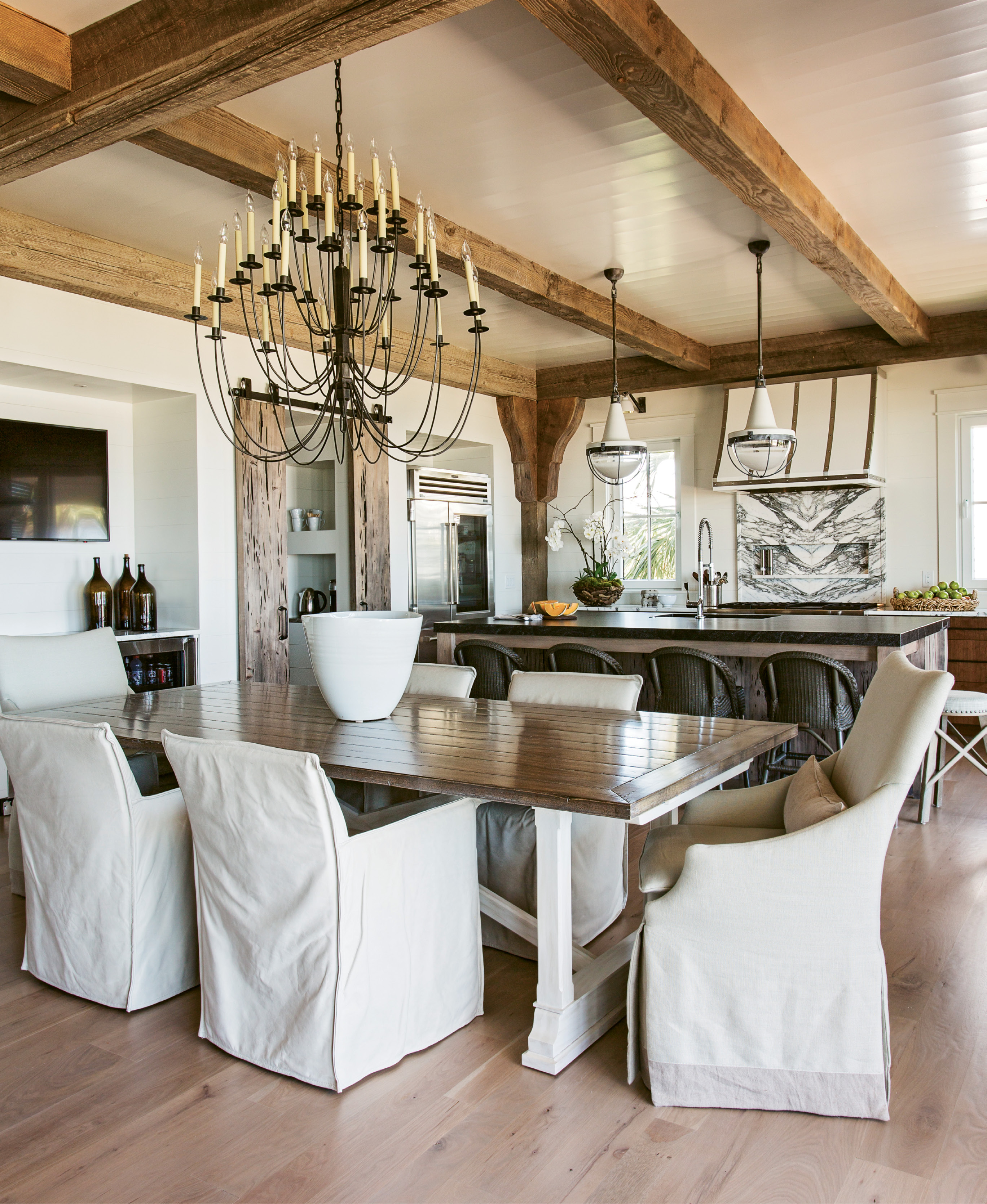 White leather chairs by Lee Industries flank the kitchen table, which can expand to accommodate 14.