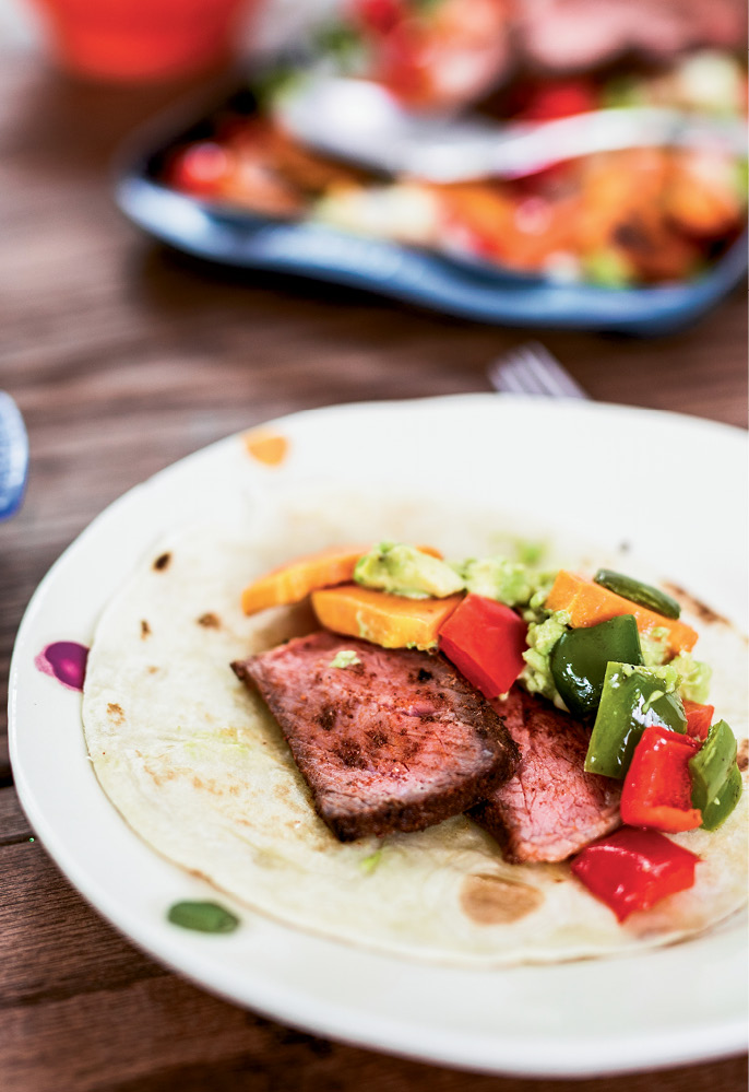 Freshly made tortillas are filled with seasoned beef, squash, peppers, and guacamole.