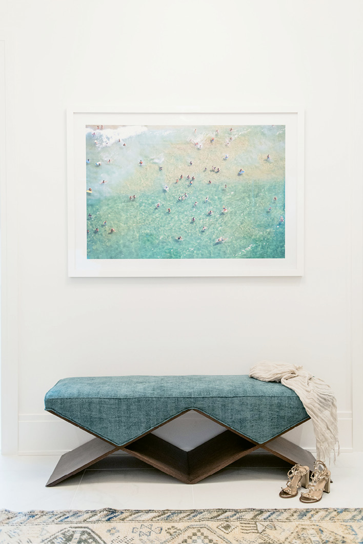 An angular, custom-designed bench (over which a coastal scene snapped by Gray Malin hangs) add modern style in spades.