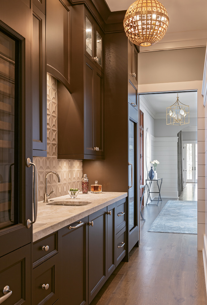 Hidden behind the main kitchen area is an innovative butler’s pantry, resplendent with floor-to-ceiling cabinets designed by Robert Paige Cabinetry.