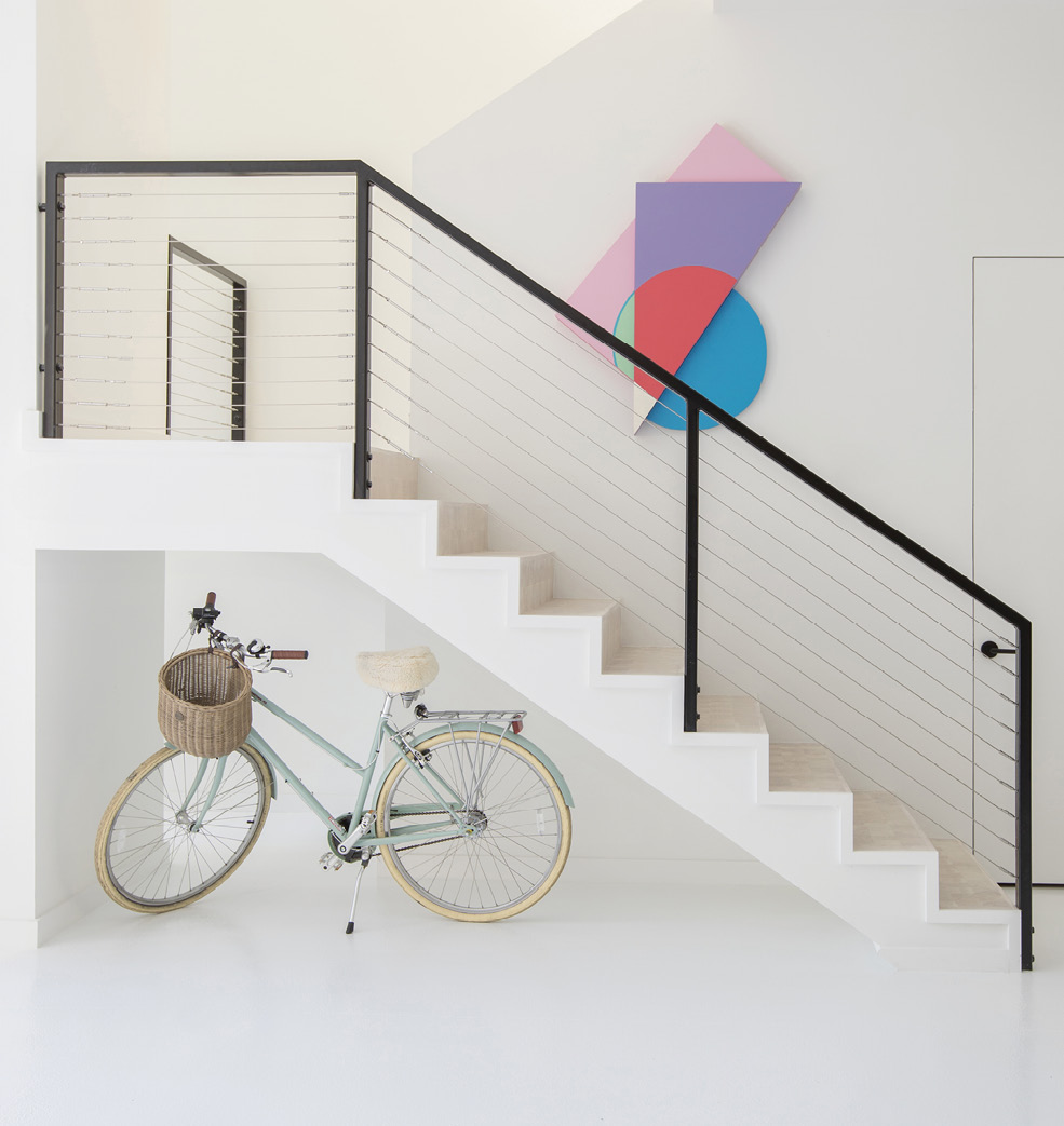 Jonathan Rypkema’s pastel wood panel provides a burst of color above the stairwell.
