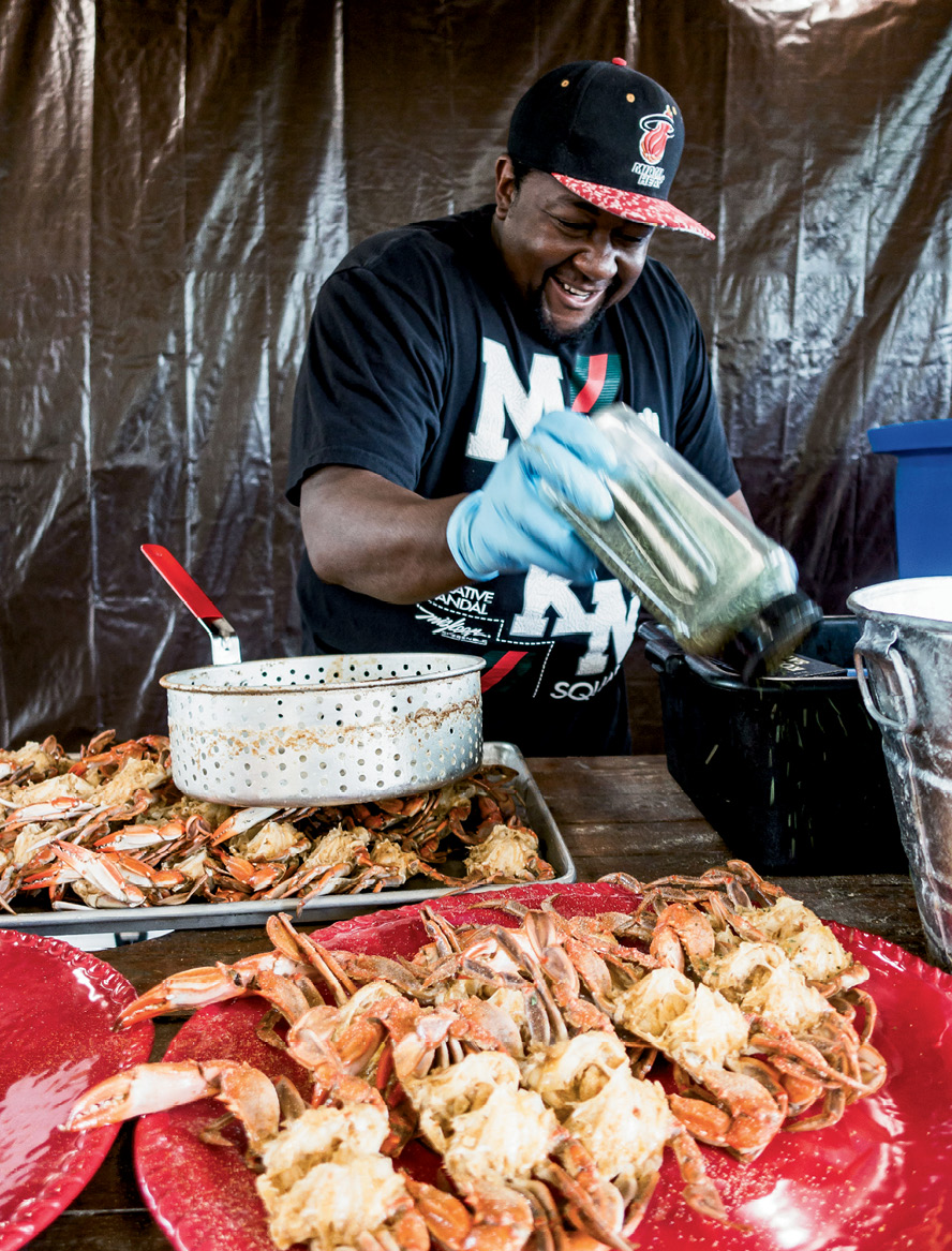 For a gathering at Lady’s Island Oyster Farm, Louis “Granny” Albany shakes spices onto local blue crabs.