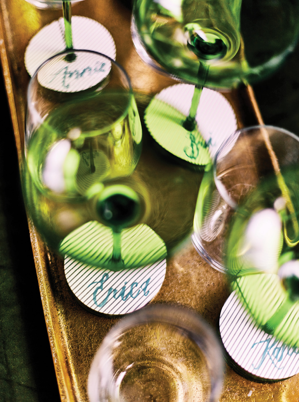 Handblown champagne glasses by Charleston enterprise Estelle Colored Glass are labeled with name tags to prevent accidental swapping.
