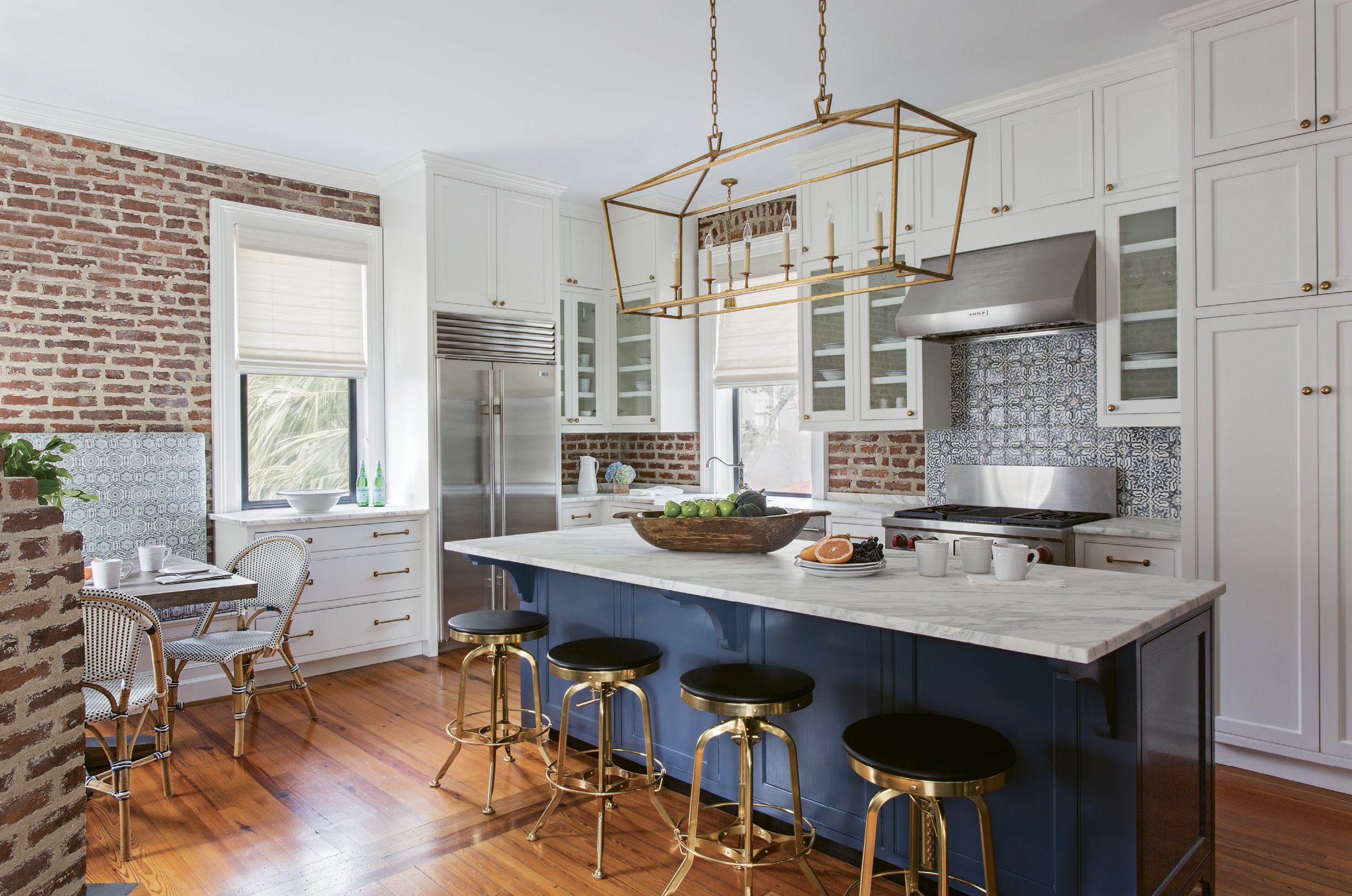 In the second-floor kitchen, Peake played off the navy blue of the island with complementary patterns in the tile backsplash and the washed linen fabric for the banquette.