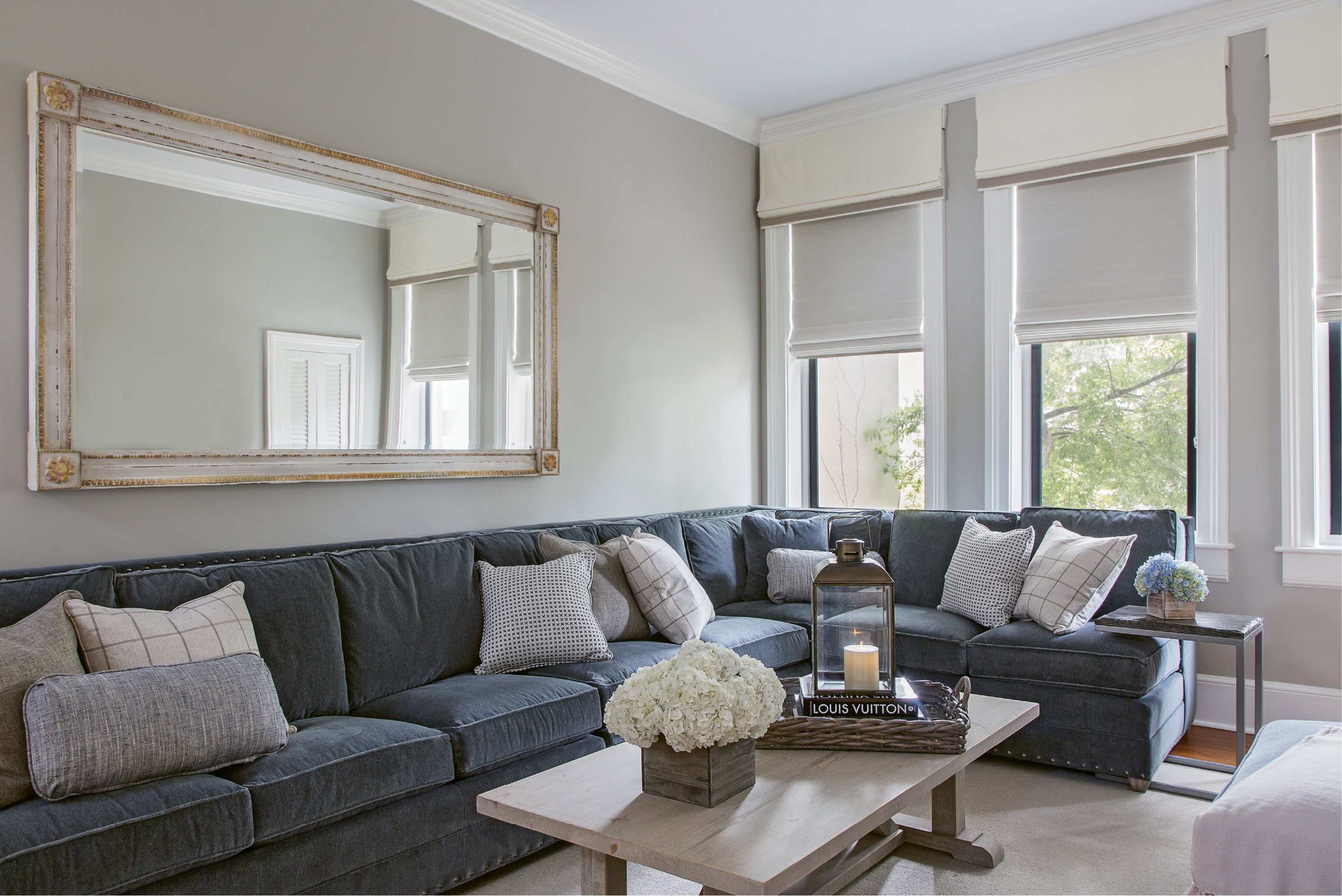 Rick’s only request for the décor? “He said he wanted a really comfortable couch,” says Kristy. The custom sectional from Vanguard offers plenty of seating in the family room. Instead of elaborate window treatments that could easily overtake the decor, Peake chose light-hued, space-saving woven shades and had the window mullions painted in “Kendall Charcoal” by Benjamin Moore for a modern look that highlights the woodwork while creating depth.