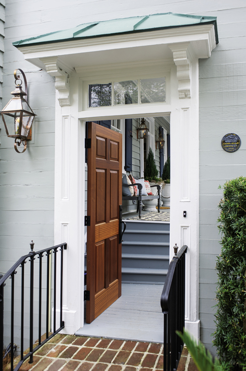 A natural mahogany front door sets off the entry’s white moulding and transom.