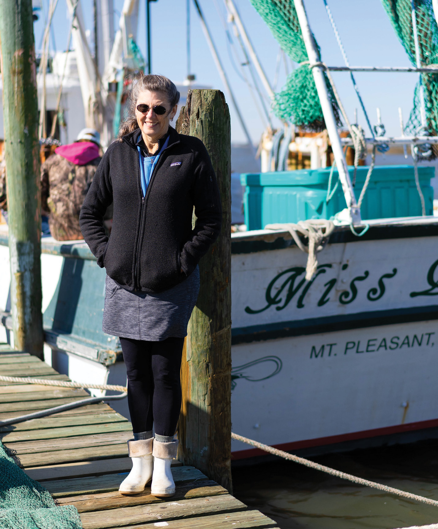 Cindy Tarvin beside the classic wooden trawler that she and her husband bought in late 2011