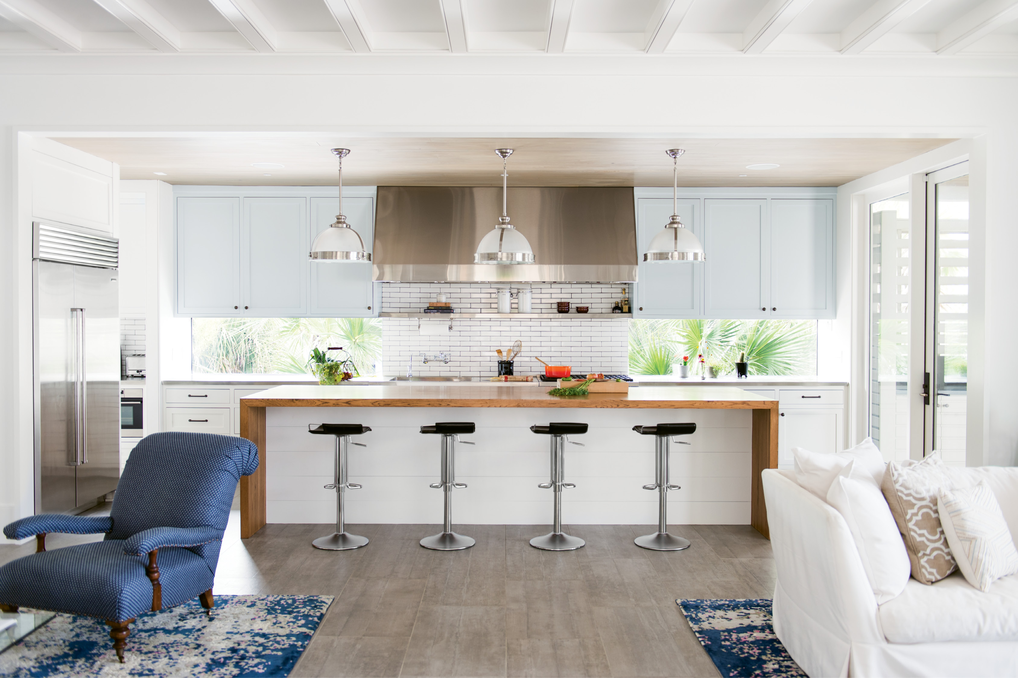 The use of windows over a traditional backsplash helps the home feel more connected to the landscape. Flush cypress ceilings and cement-tile flooring reinforce the modern feel.