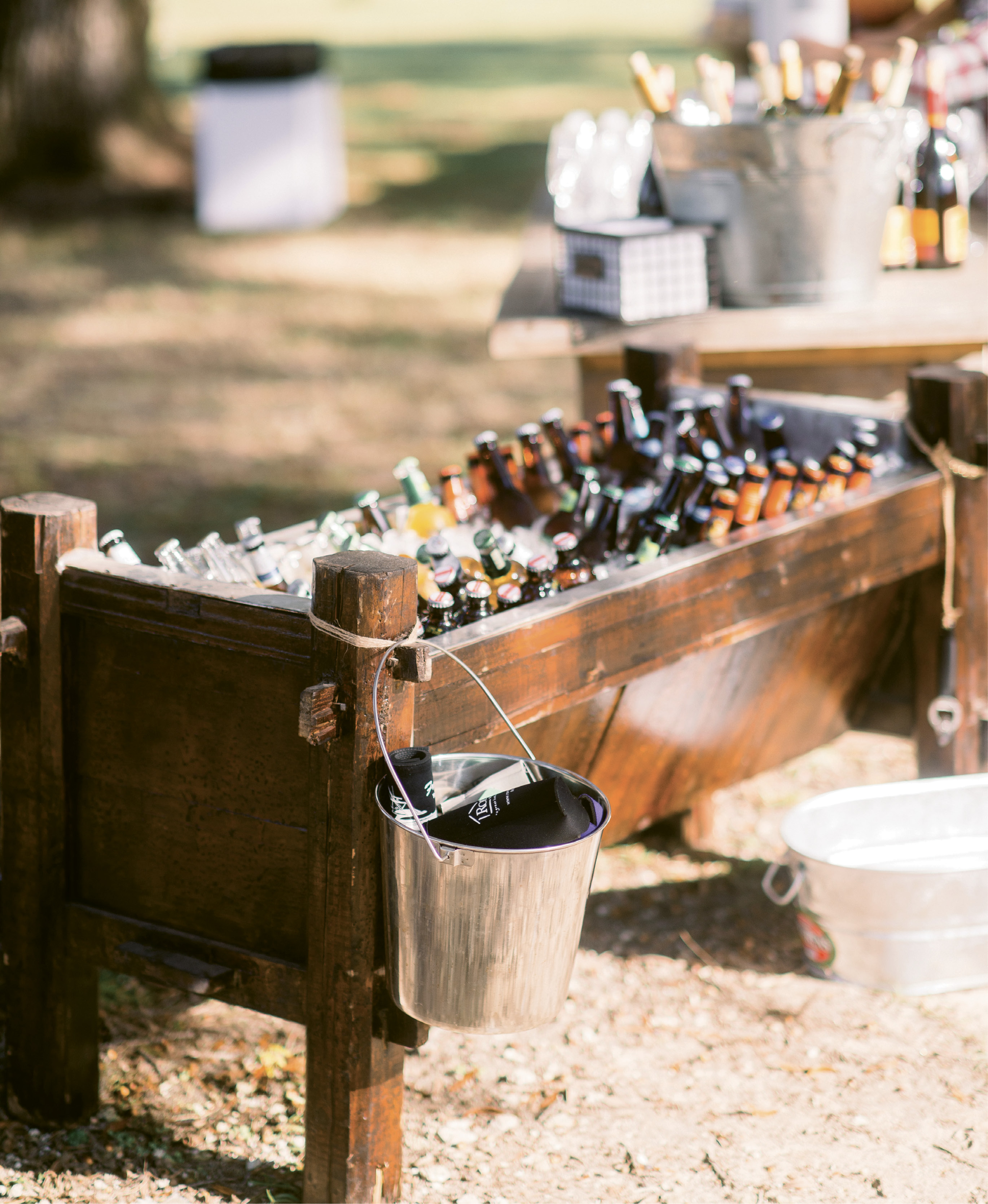 Bottoms Up: A wooden trough rented from Snyder Events kept the serve-yourself beer stash iced while a galvanized pail secured with rope held koozies and added to the day’s rustic aesthetic.