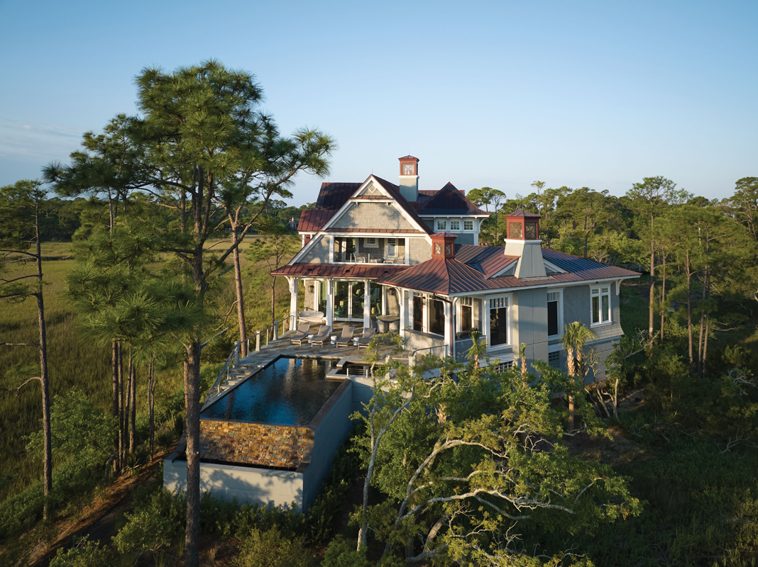 When architect Marc Camens designed this classic Nantucket-style, shingle-clad home on the northeastern edge of Kiawah Island, he had to maximize every square inch of space. Surrounded on three sides by marsh, the shape was dictated by the curves and width of the land. Camens angled the main living spaces to capture the panoramic view of the Kiawah River and Folly Beach beyond, while the home’s entrance, garage, and driveway bring up the rear.