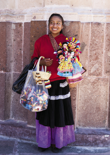A local girl sells her handmade dolls in El Jardín.