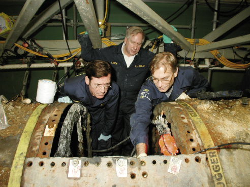 With Warren Lasch, former chairman of Friends of the Hunley, and Dr. Robert Neyland, then Hunley Project director, peering into the interior of the historic submarine in 2001