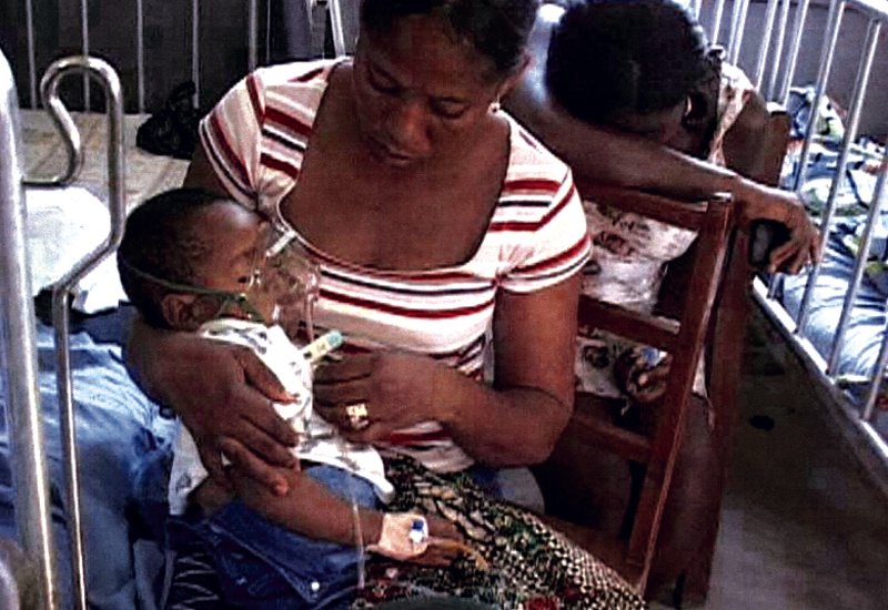 A woman cares for a baby on a respirator in a hospital in Ghana