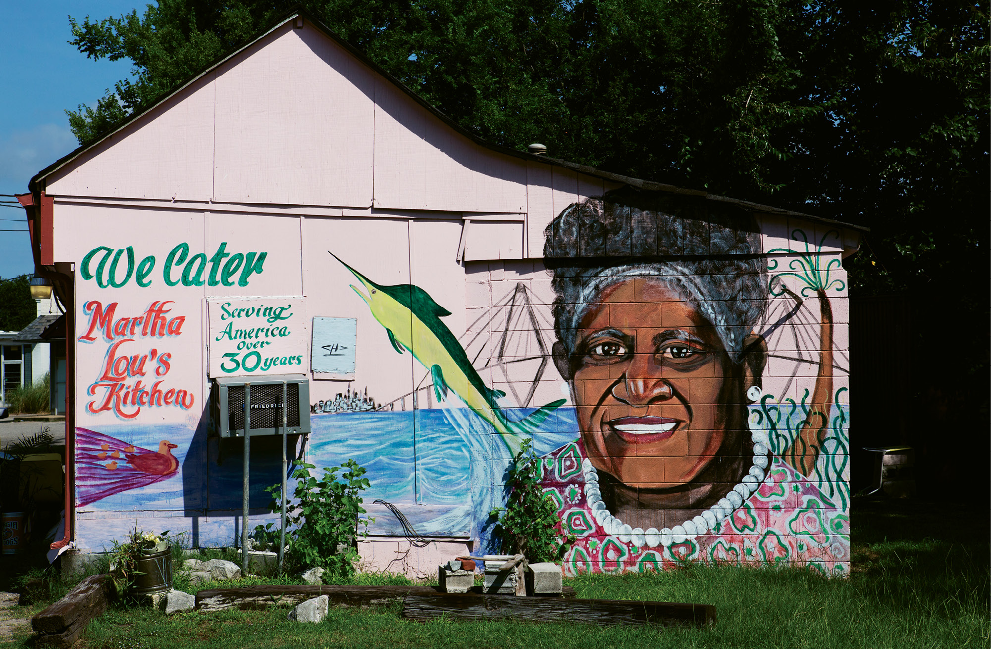 Untitled  by Charles Desaussure  2012  Martha Lou’s Kitchen  (1068 Morrison dr., Peninsula)  for decades, locals and visitors alike have sought out the famous pink cinder-block building for the addictive fried chicken inside. in 2012, the colorful exterior got an upgrade, an immense portrait of Martha Lou herself, painted by late Lowcountry artist Charles Desaussure, who passed away the following year. His work can be found on and in many area businesses, including Ravenel Seafood and Red Piano Too Art Gallery in St. Helena.