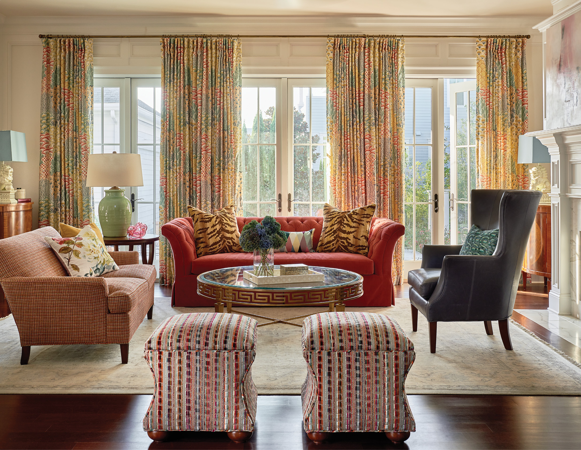 A tufted-velvet sofa and smaller settee in a soft, sophisticated tweed offer French flair in the family room, while still providing comfort for everyday family living. The bold colors are unified by bright drapes in the Clarence House “Shere Khan” fabric.